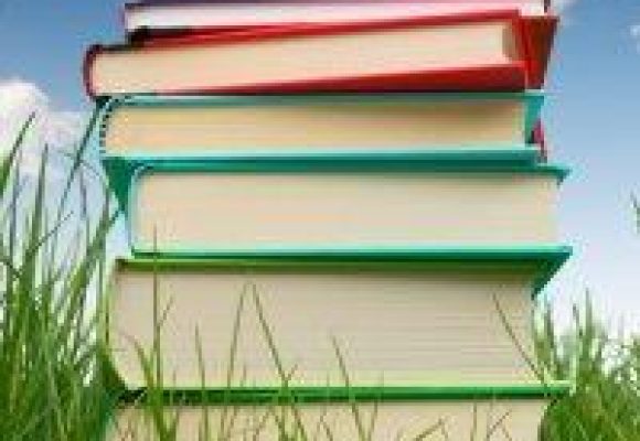 Colorful stack of books against a blue sky.